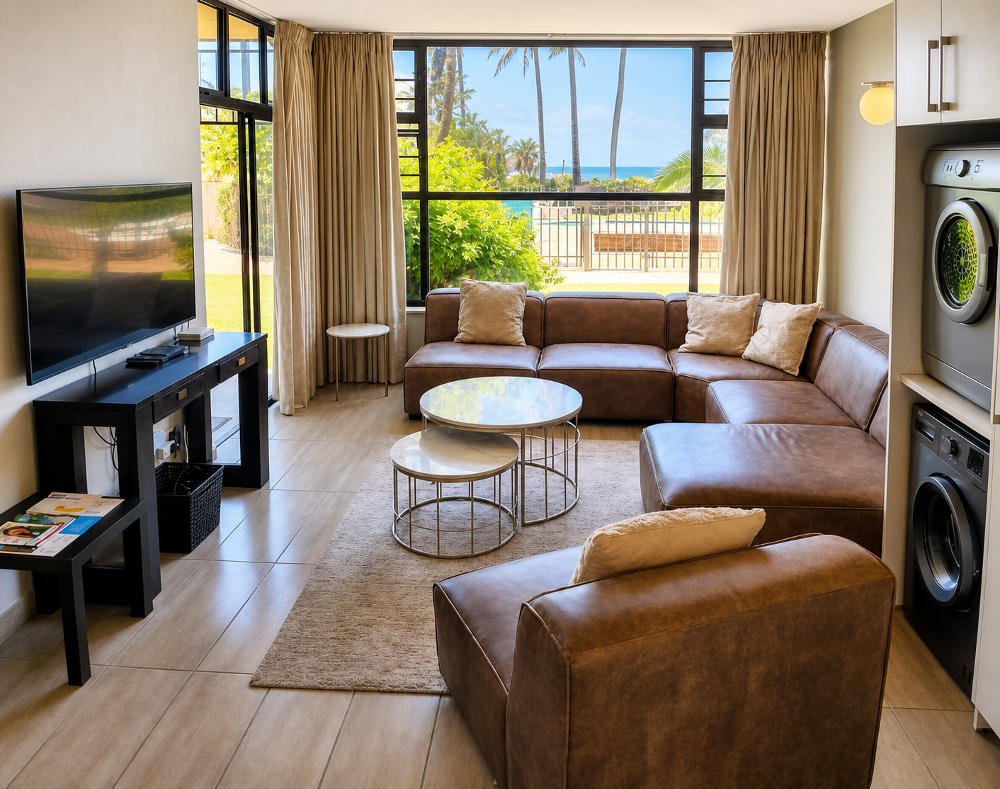 The lounge at Pebbles looking out through wide windows to palms and the sea beyond